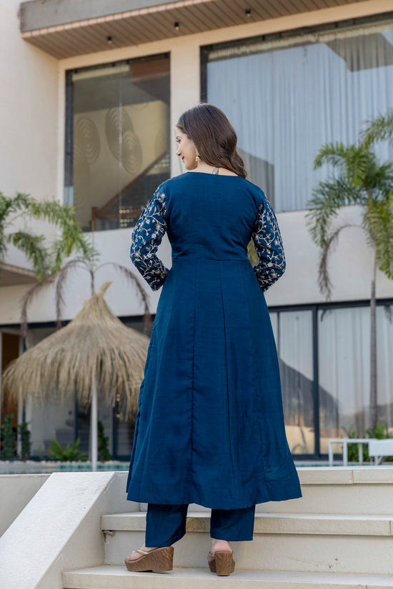 Woman wearing a royal blue embroidered Anarkali suit by Pusti Feni.