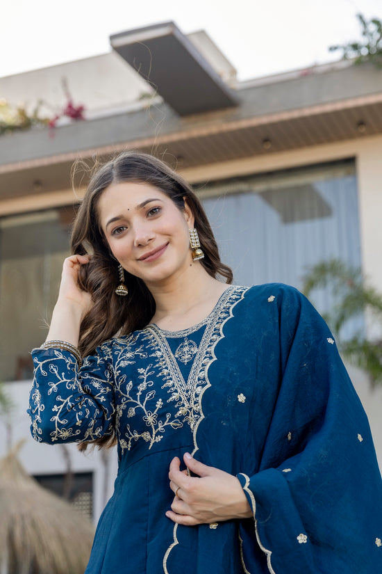 Woman wearing a royal blue embroidered Anarkali suit by Pusti Feni.