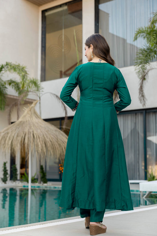 Back view of a woman wearing a bottle green embroidered Anarkali suit by Pusti Feni.