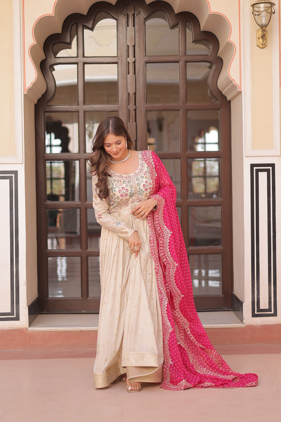 Woman in cream Cosmos Jacquard embroidered gown with pink Bandhani dupatta by Pushti Feni